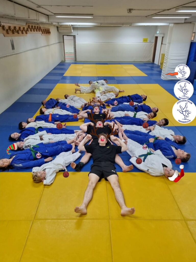 Ein Weihnachtsbaum geformt aus Judo-Kindern, die am Boden liegen